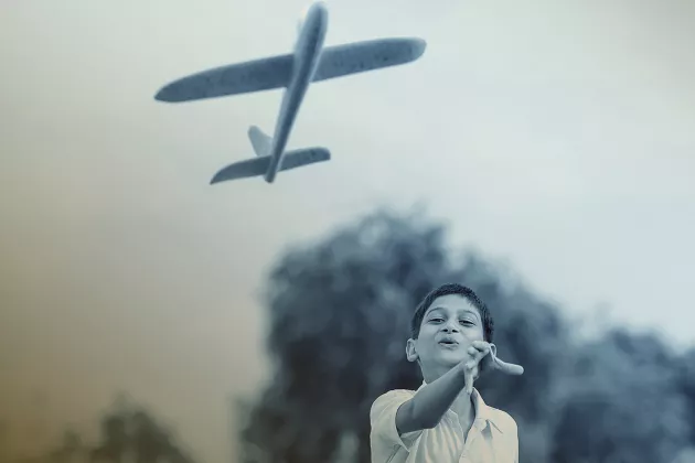 Photo of a boy playing with an airplane toy