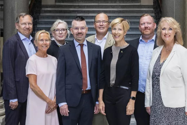 A group of eight people, both men and women. Photo