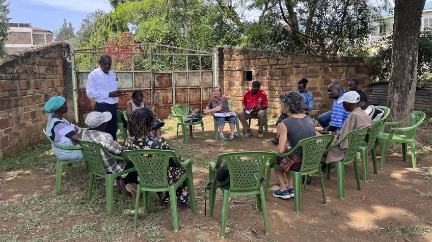 People on chairs outdoors discussing. photo