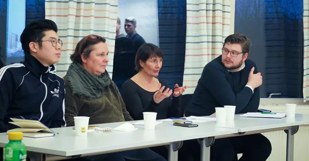 Four people sitting down at a table discussing